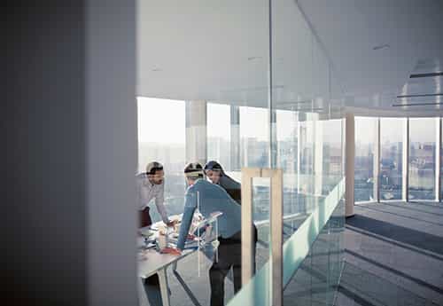 commercial real estate advisers discuss market dynamics in a glass conference room